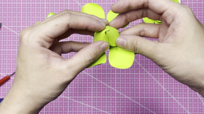 Use a glue gun to attach two opposite petals together, then gently turn the petals up